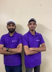 Two male team members in purple GCCTVMS uniforms standing with arms crossed, representing the company's commitment to security and virtual guard services.
